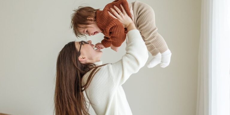 nanny holds baby in air hiring a nanny saved my marriage